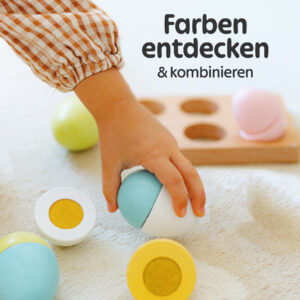 Kind spielt mit bunten Holz Spielzeug Eier von Merle Toys und kombiniert Farben – pädagogisches Kinderküchen Zubehör aus Holz ab 2 Jahren.