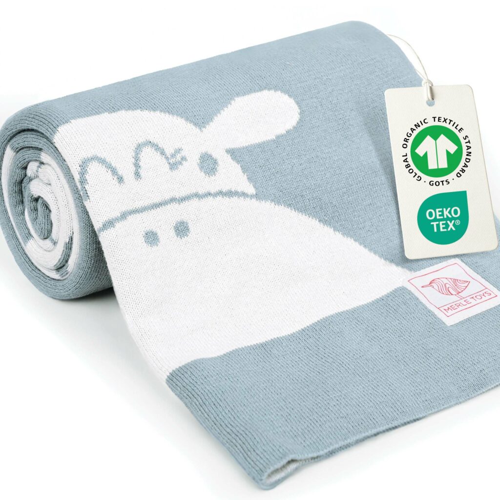 Blaue Babydecke aus Baumwolle, gerollt präsentiert mit GOTS- und OEKO-TEX-Zertifizierung; hochwertige gestrickte Decke fürs Baby und perfekte Meilenstein Decke.