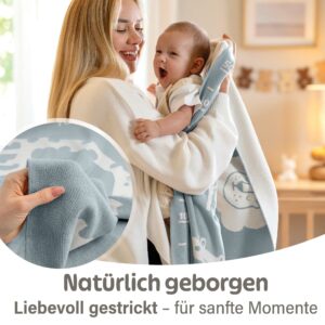 Mutter hält ihr Baby eingehüllt in eine blaue Babydecke aus Baumwolle; liebevoll gestrickte Decke Baby für sanfte Momente und vielseitig als Meilenstein Decke einsetzbar.