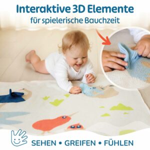 Baby auf der Merle Toys Baumwoll Babydecke bei der Bauchzeit, entdeckt die interaktiven 3D-Elemente der Bio Babydecke Savannenfreunde zum Greifen, Fühlen und Spielen.