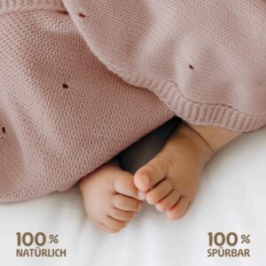 Babyfüße unter Merle Toys Babydecke Strick – Babydecke Bio Baumwolle rosa, weich und hautfreundlich.