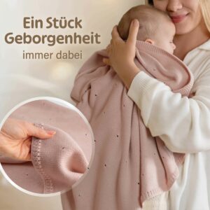Mama hält Baby zugedeckt mit Babydecke Strick von Merle Toys – rosa Babydecke aus Bio Baumwolle, kuschelig weich zur Babyhaut.