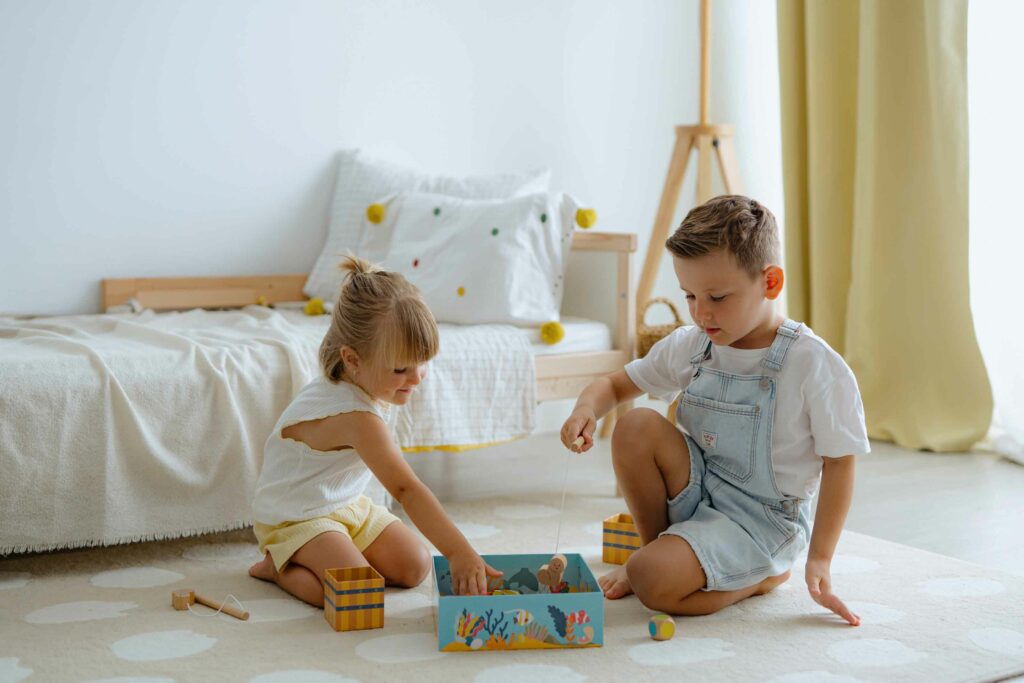 Zwei Kinder spielen gemeinsam ein farbenfrohes Holz-Angelspiel – ein motorikförderndes Spielzeug und eine tolle Geschenkidee für 2-Jährige. Ideal als sinnvolles Geschenk für 2-Jährige für Jungs & Mädchen oder als Weihnachtsgeschenk für 2-Jährige.