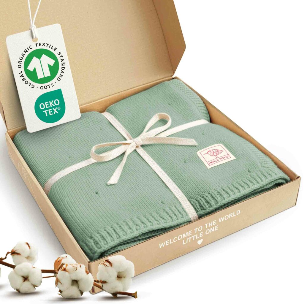 Merle Toys_Bio Baumwoll Babydecke Strick in Grün in Geschenkbox verpackt; Babydecke gestrickt mit GOTS- und OEKO-TEX-Label, Ideales Geschenk für Neugeborene.