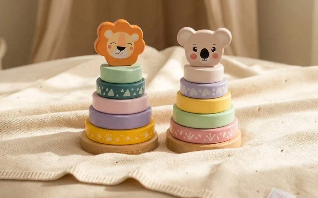 Zwei bunte Stapeltürme aus Holz mit abgerundeten Holzringen und Tierköpfen (Löwe und Koala) für Babys und Kleinkinder.